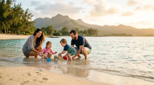Famille avec enfants en bas âge sur une plage de sable blanc avec lagon turquoise protégé et filaos en arrière-plan à La Réunion