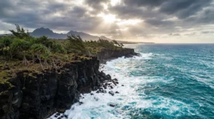 Paysage dramatique du Sud Sauvage de La Réunion avec falaises de basalte noir et océan déchaîné