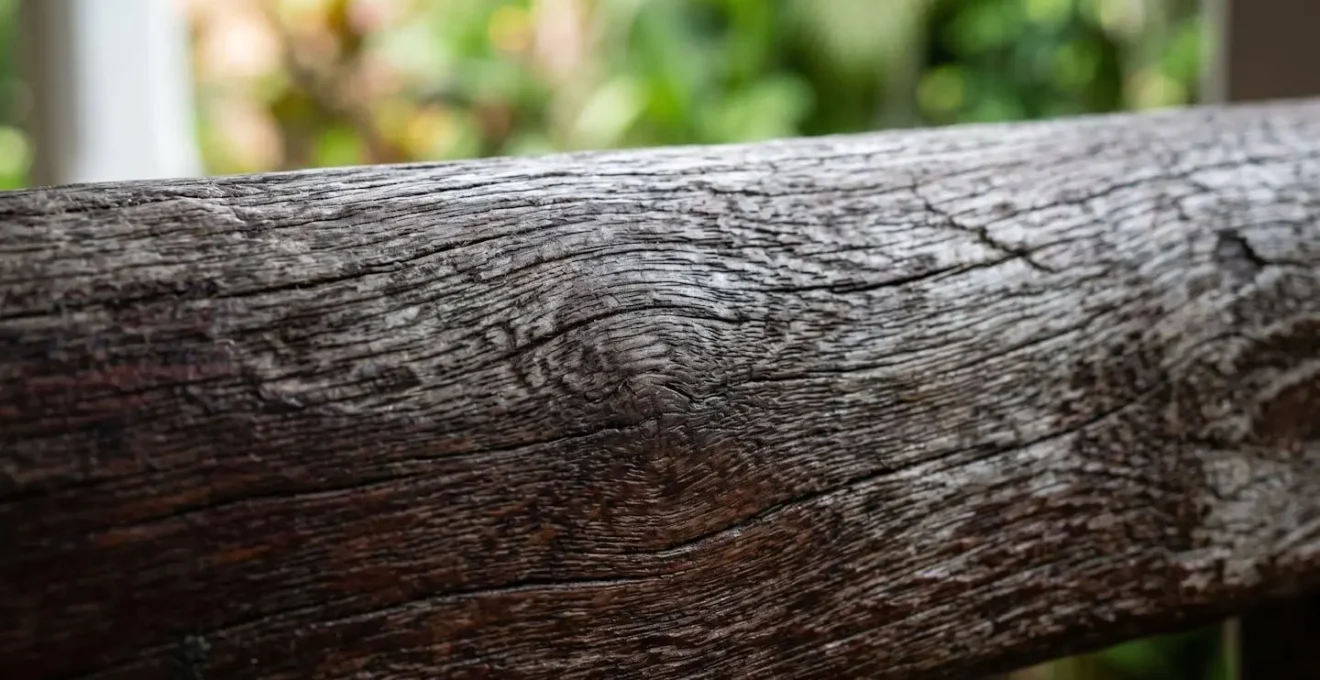 Détail macro de bois créole ancien montrant les veines naturelles et la patine protectrice