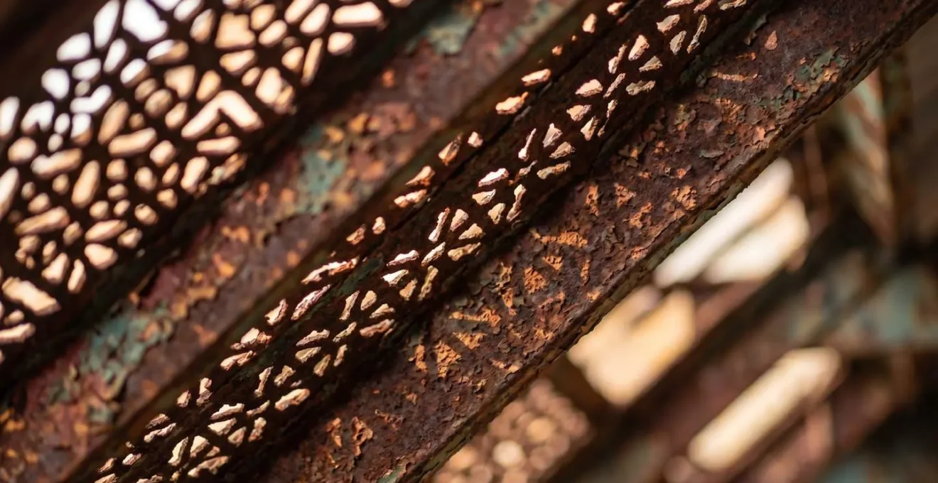 Détail macro d'une dentelle de tôle ornementale sur architecture industrielle ancienne